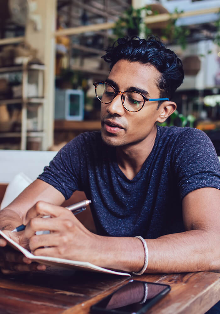 Patient with glasses writing in diary